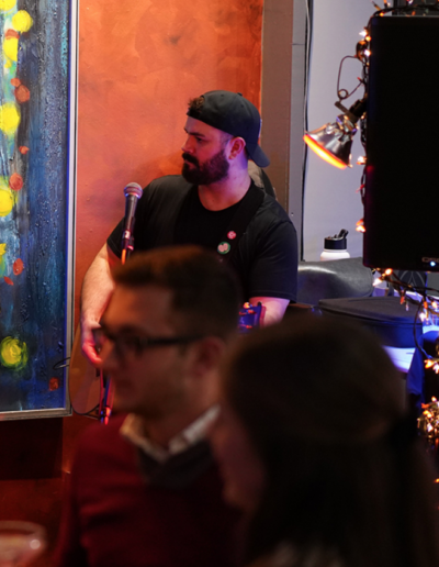 Jordan Barnett singing into a microphone at Firefly bar in Toledo, OH